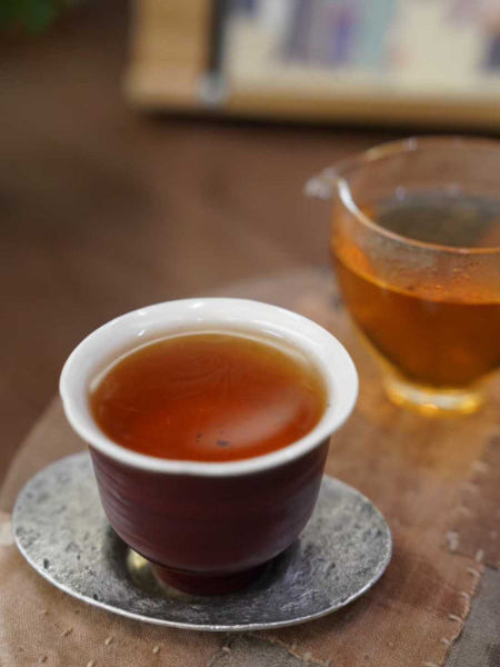 Tea cup and glass with tea on a wooden surface