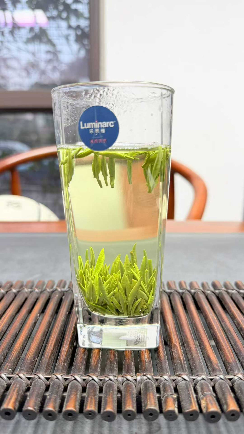 Zhu Ye Qing · 2026 First Spring | High-Mountain Bamboo Leaf Green Tea Clear glass with green tea leaves on a wooden surface, featuring a Luminear logo.