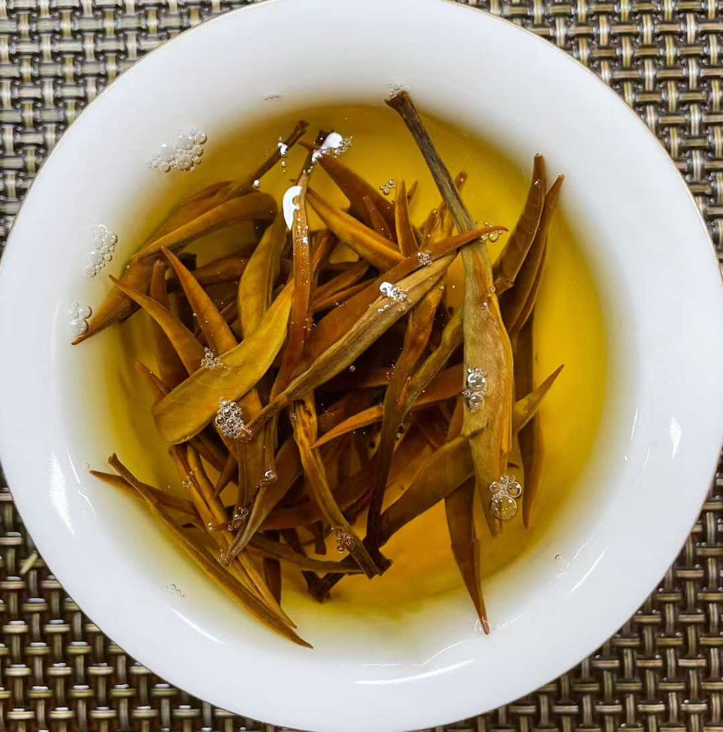 Golden Needle Black Tea 2026 New Harvest Tea leaves in a white bowl with a textured background