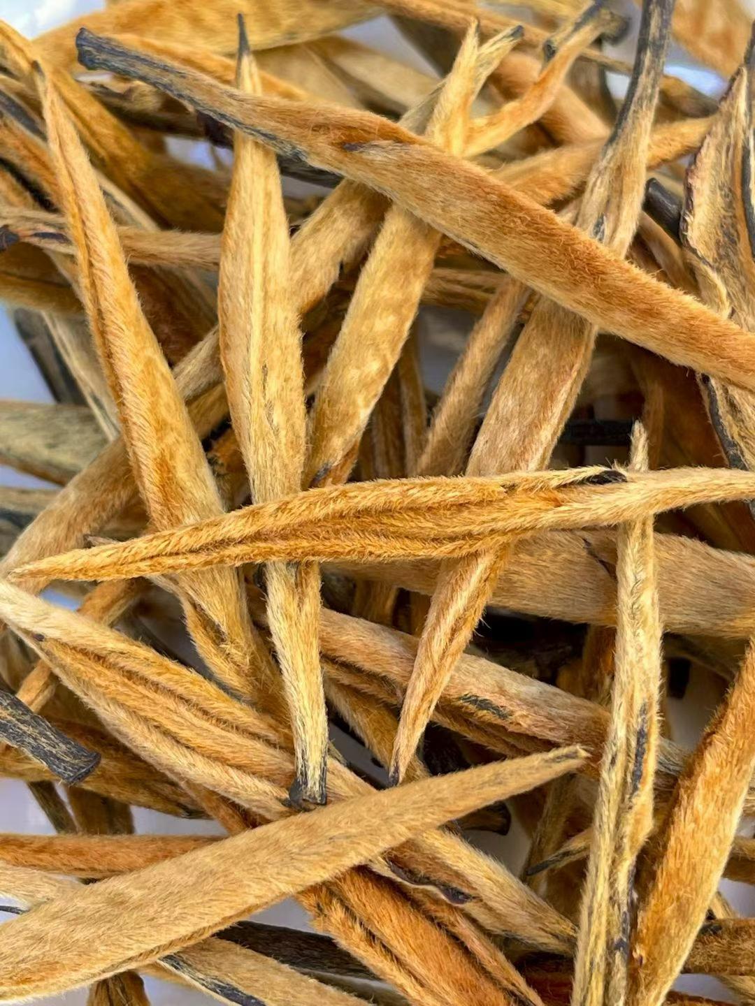Golden Needle Black Tea 2026 New Harvest Close-up of dried tea leaves with a blurred background