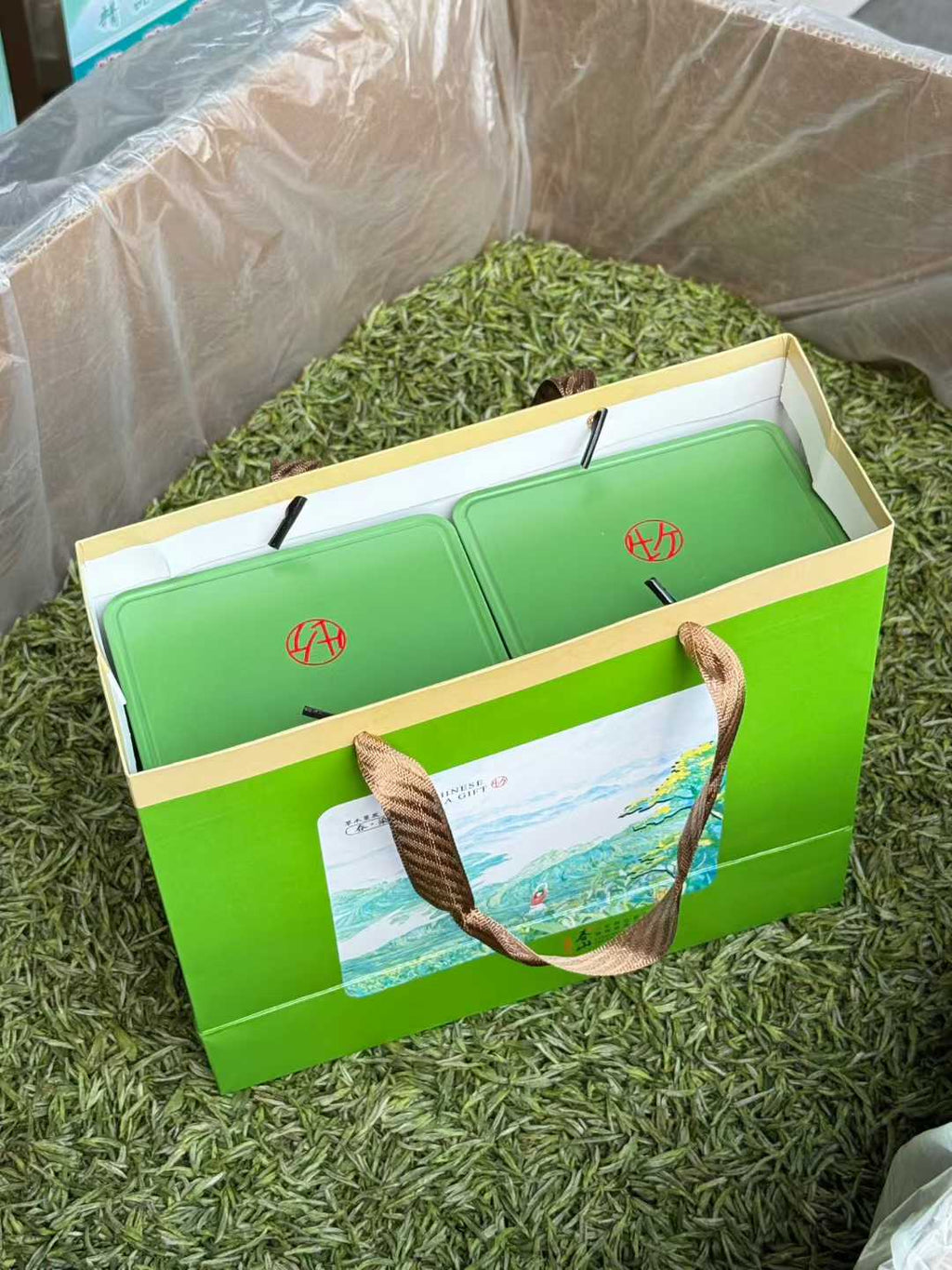 Green tea packaging with a brand logo on a grassy background. 2026 First Harvest Huangshan Maofeng – Early Spring Imperial Green Tea