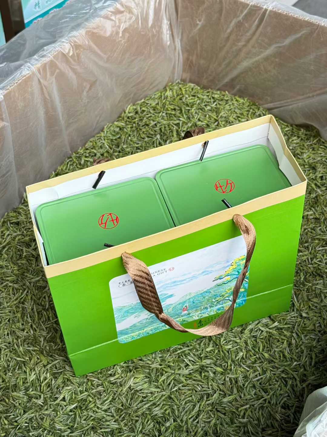 Green tea packaging with a brand logo on a grassy background. 2026 First Harvest Huangshan Maofeng – Early Spring Imperial Green Tea