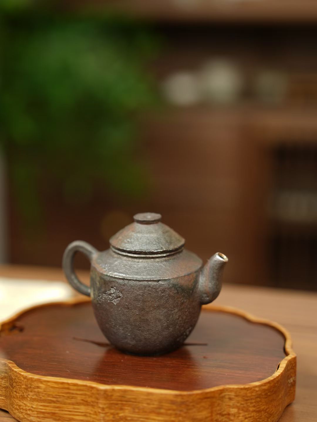 Teapot on a wooden stand with a blurred background