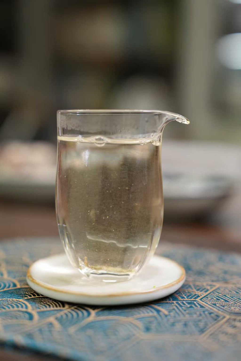 2017 Wild-Grown Silver Needle White Tea (Fuding)  Glass teapot with tea on a textured surface