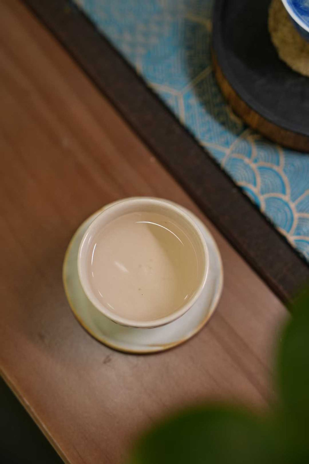 2017 Wild-Grown Silver Needle White Tea (Fuding)  Ceramic bowl on a wooden surface with a blurred background