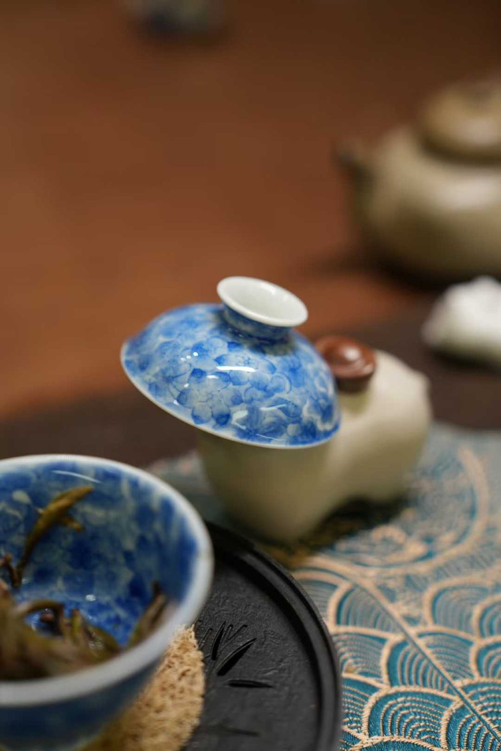 Tea set with blue and white ceramic cups on a textured surface