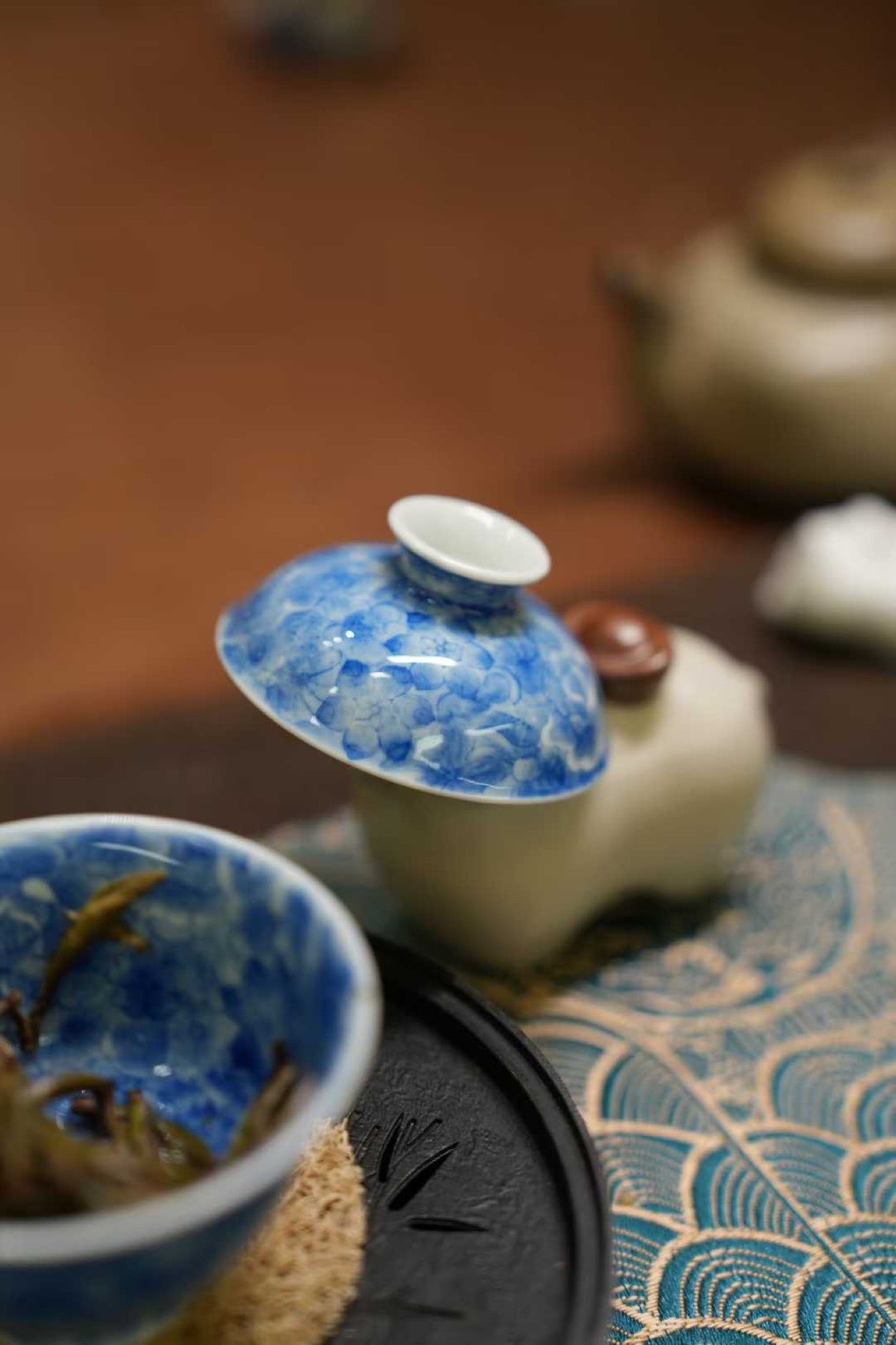 Tea set with blue and white ceramic cups on a textured surface