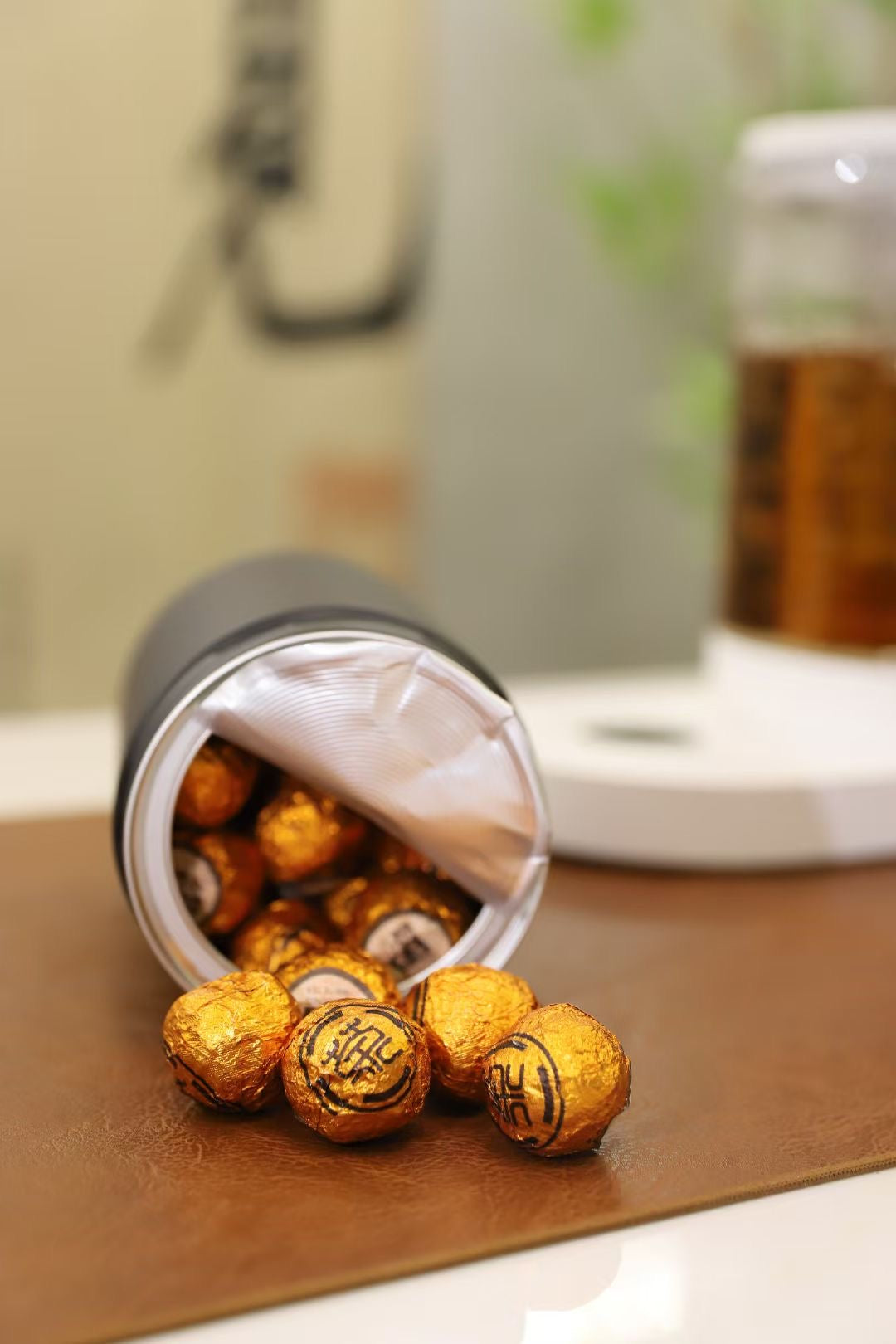 Rolo candies spilling out of a container on a brown surface with a blurred background